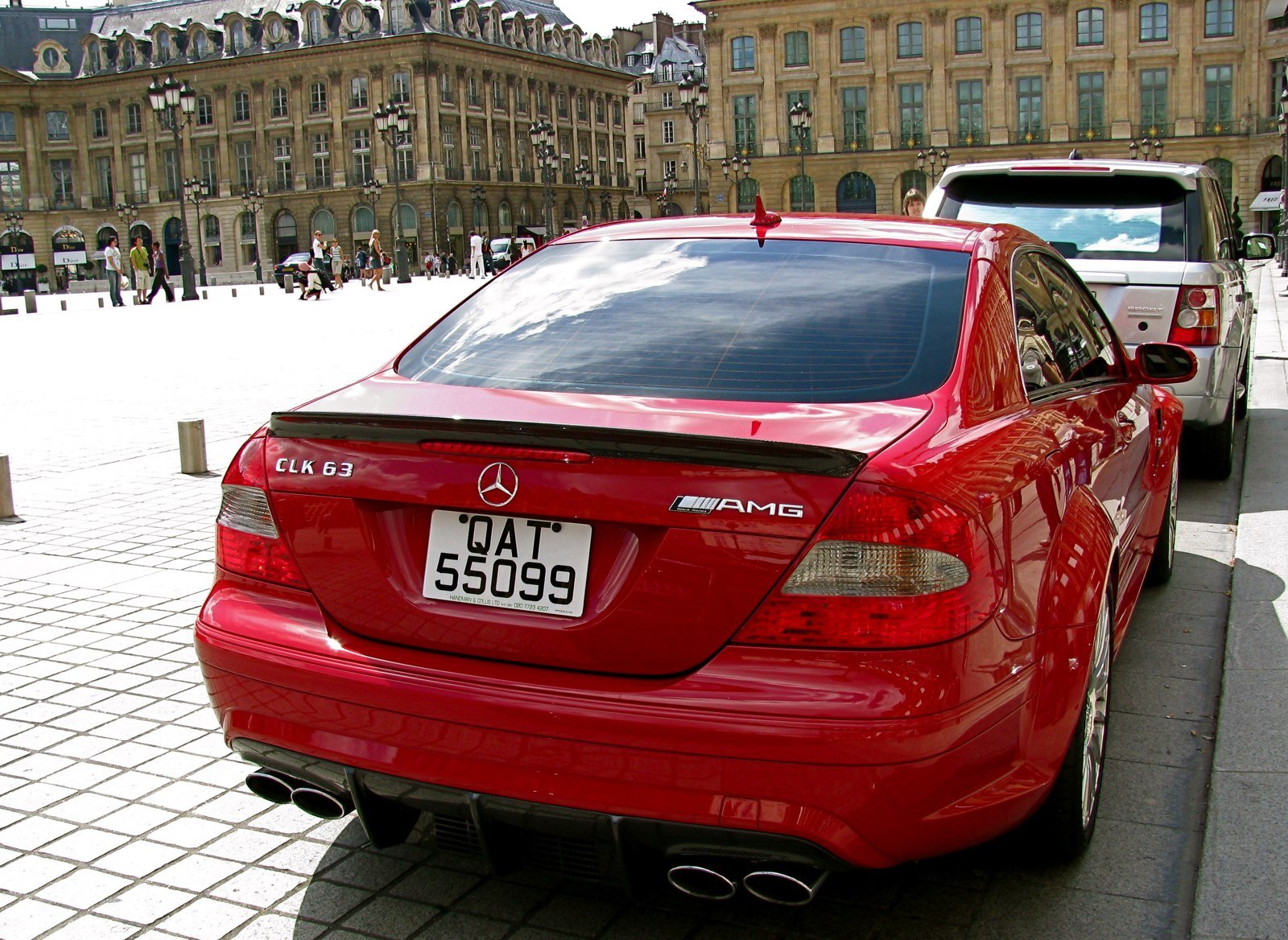 Red Mercedes-Benz CLK 63 AMG Black Series coupe photographed from the rear three-quarter angle, showing its wide rear fenders, trunk spoiler and rear cooling opening.