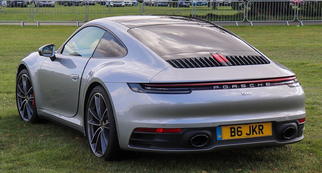 Archival silver 2019 Porsche 911 Carrera S coupe, 992.1 generation, photographed from the rear three-quarter angle at Salon Privé in September 2019.