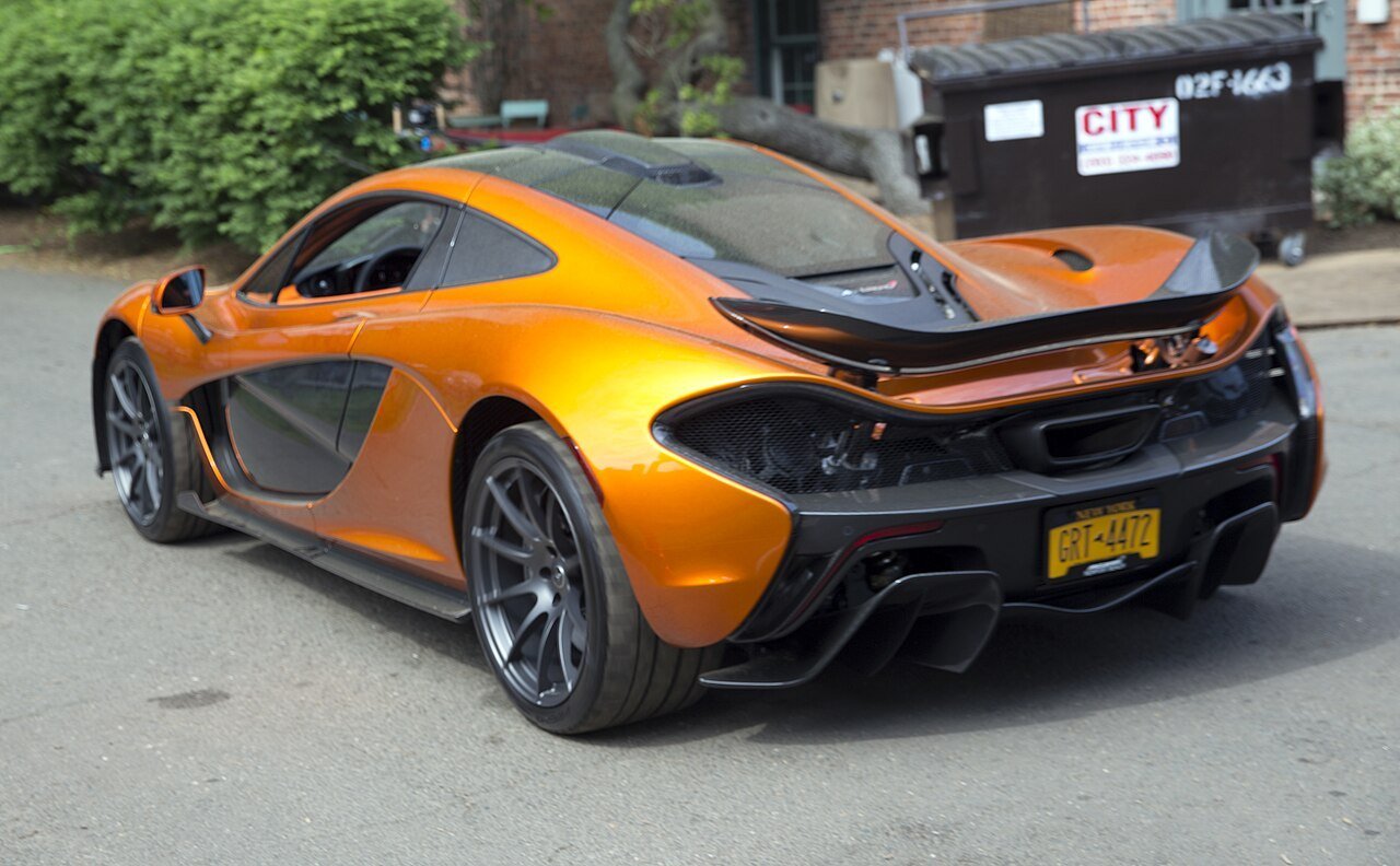 The same orange 2014 McLaren P1 road coupe viewed from the rear-left at Greenwich in 2018.