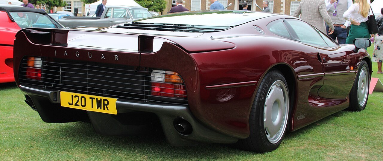 The same burgundy Jaguar XJ220 coupe, registration J20 TWR, viewed from the rear at London Concours 2022.