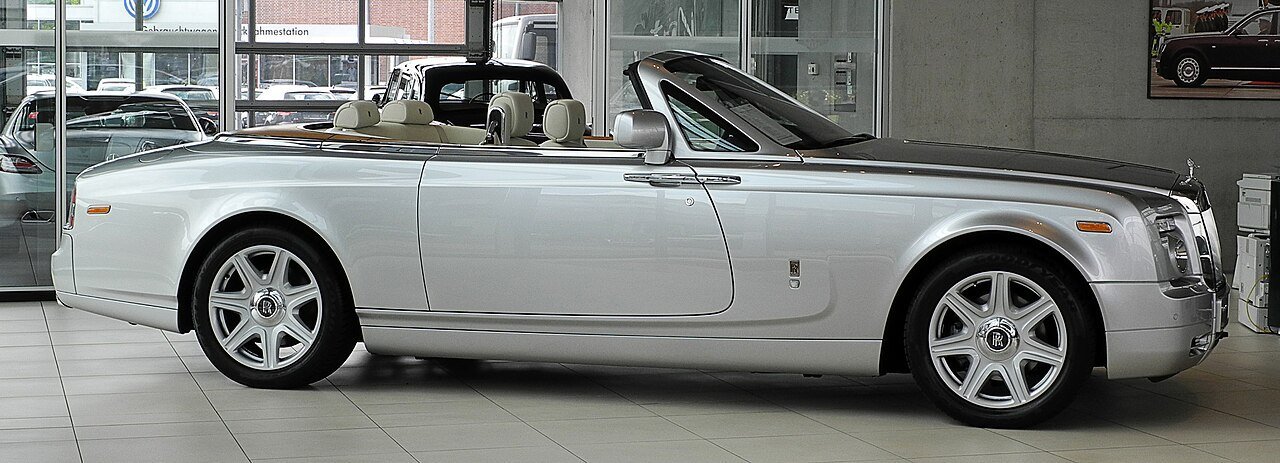 The same silver Series I Rolls-Royce Phantom Drophead Coupé shown in full side profile with its roof lowered.