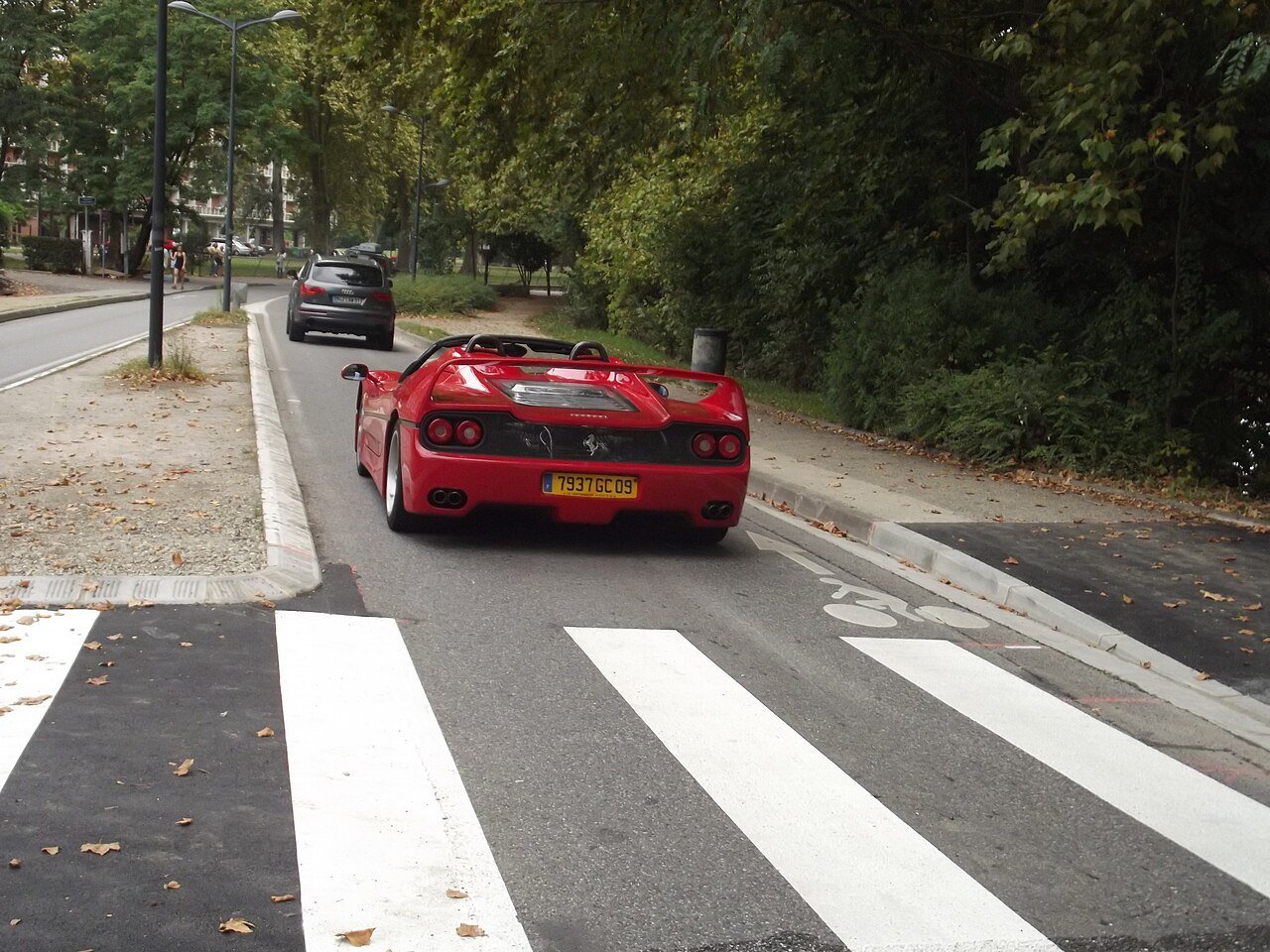 Red Ferrari F50, roof removed, photographed from behind on a Toulouse street.