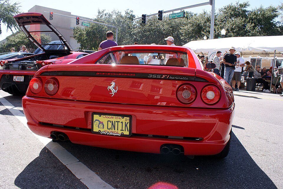 Rear view of a red Ferrari 355 F1 Berlinetta, with its model badge and four round taillights visible.