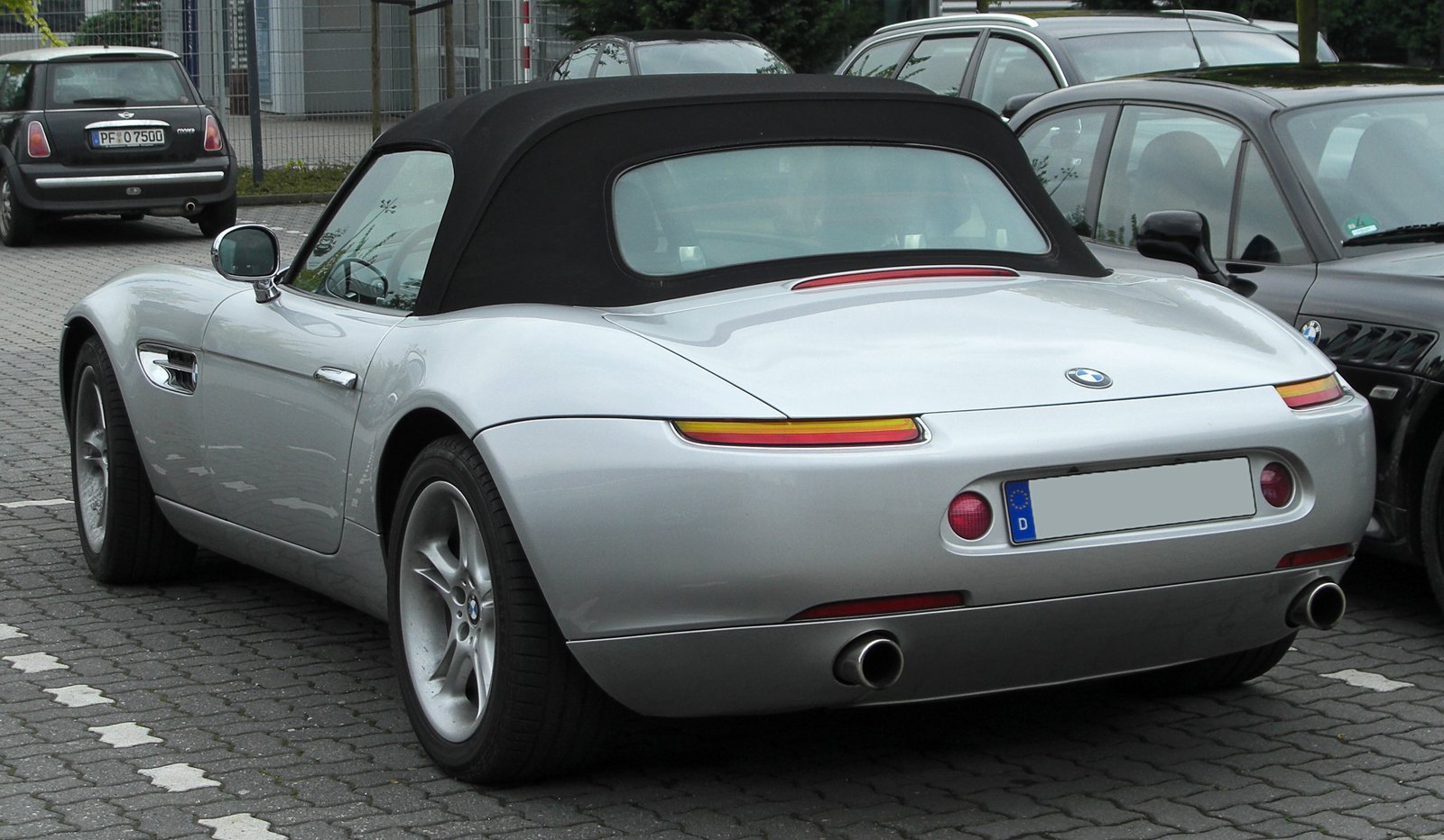 Silver BMW Z8 roadster with soft top raised, rear three-quarter view.