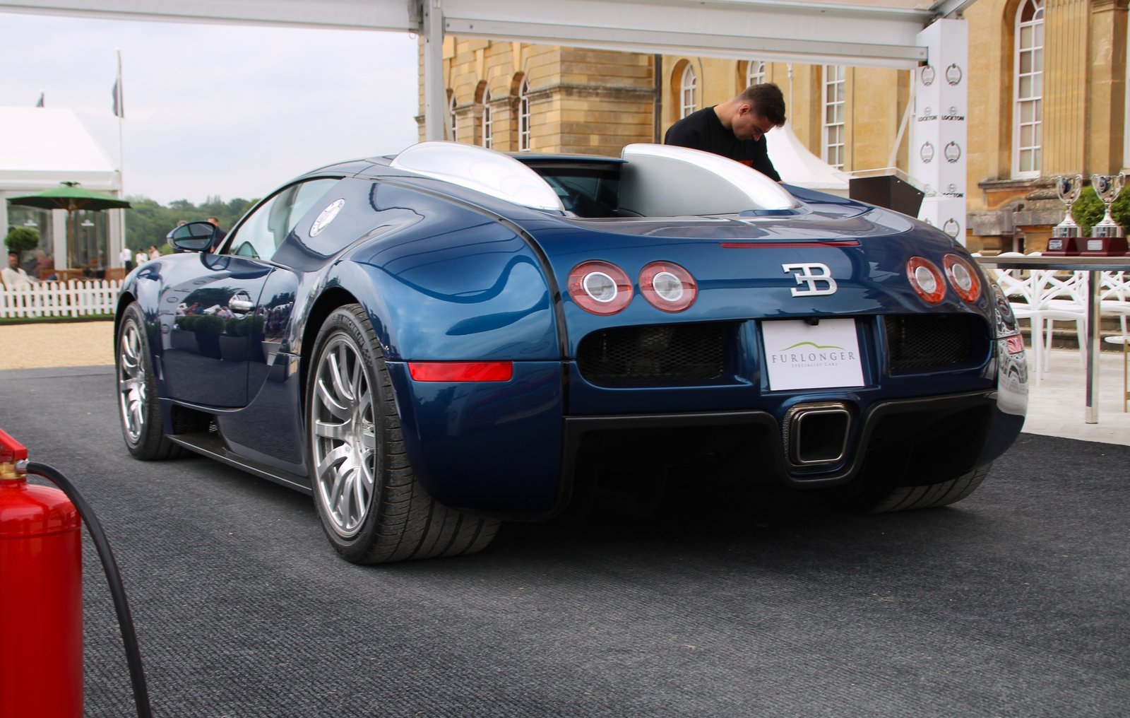 Blue 2007 Bugatti Veyron 16.4 fixed-roof coupe photographed from the rear three-quarter angle at Salon Privé in 2024.