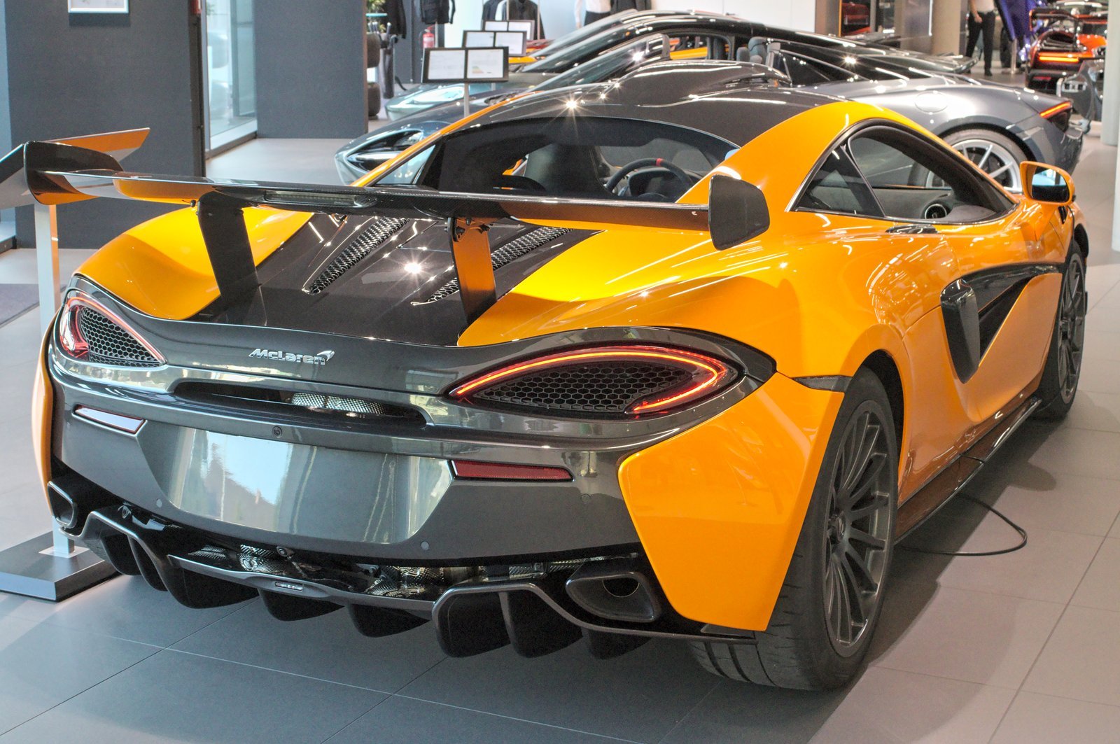 Orange McLaren 620R coupe photographed from the rear three-quarter angle at Motorworld in 2020.